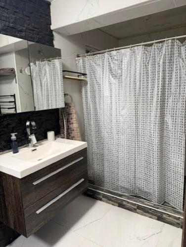 a bathroom with a sink and a shower curtain at Comfort House in Manuel F. Martínez