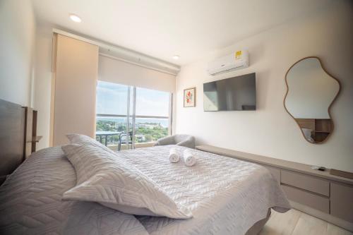a bedroom with a bed with a mirror and a tv at Refugio Del Mar Bello Horizonte Playa Dormida in Santa Marta