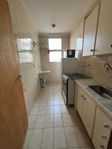 a small kitchen with a sink and a stove at Apes Raizes Douradas in Campinas