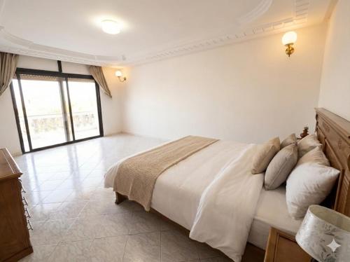 a white bedroom with a bed and a window at Palace with Private Pool in Tamaris