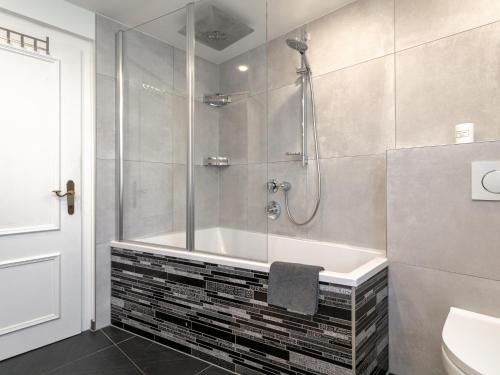 a bathroom with a shower and a bath tub at Kaiser Chalet Ebbs in Ebbs
