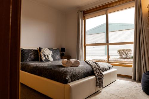 a bedroom with a bed with a large window at Valentine House in Hadspen
