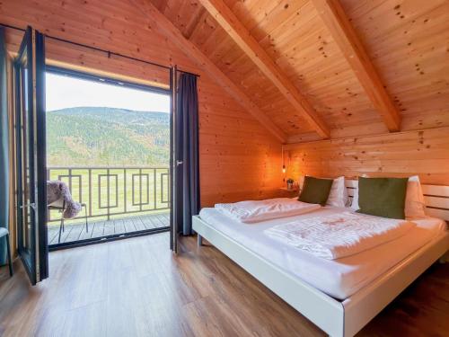 a bedroom with a bed and a large window at Rattendorf 15A in Rattendorf