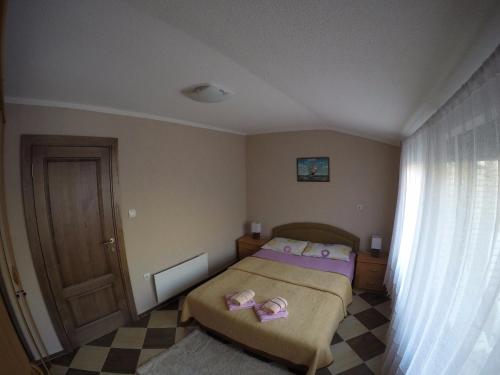 a bedroom with a bed with pink slippers on it at Apartments Krivokapic in Kotor