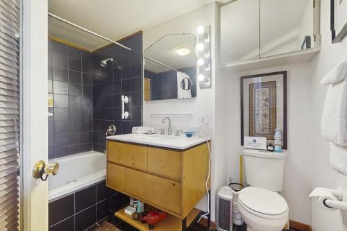 a bathroom with a sink and a toilet and a tub at Tranquil Tides Cottage in Langley
