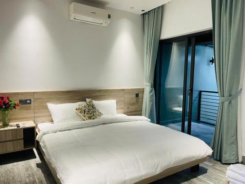 a bedroom with a large white bed and a window at Win Home Huế in Hue