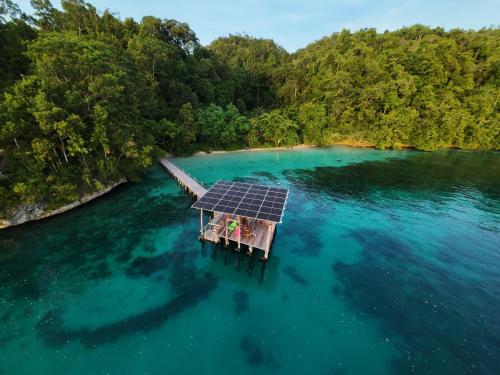 an island with a solar panel on the water at Raja Ampat Eco Lodge in Tapokreng