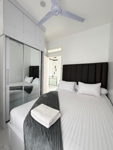 a bedroom with a large bed with a ceiling fan at Villa Shafa Marwa in Bukittinggi