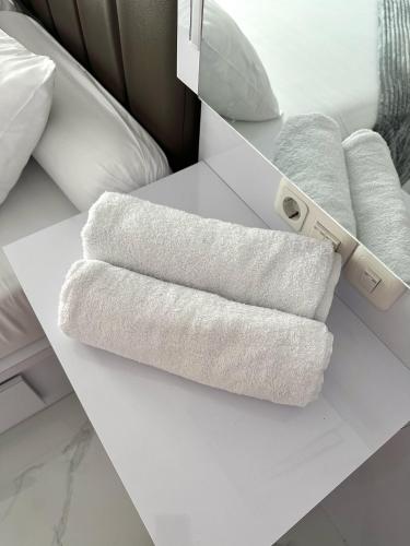 a pile of towels sitting on top of a bed at Villa Shafa Marwa in Bukittinggi