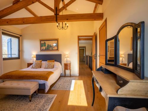 a bedroom with a bed and a dresser and a mirror at 7-Bedroom Tarn Villa with Spa in Damiatte
