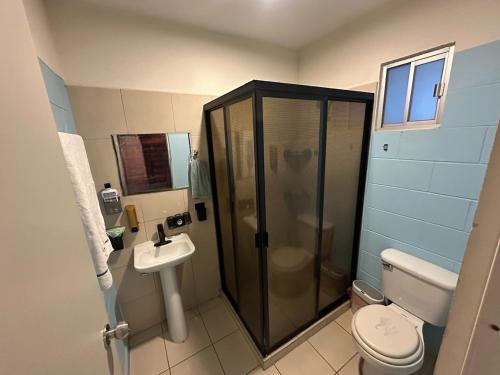 a bathroom with a shower and a toilet and a sink at Acapulco in Mazatlán