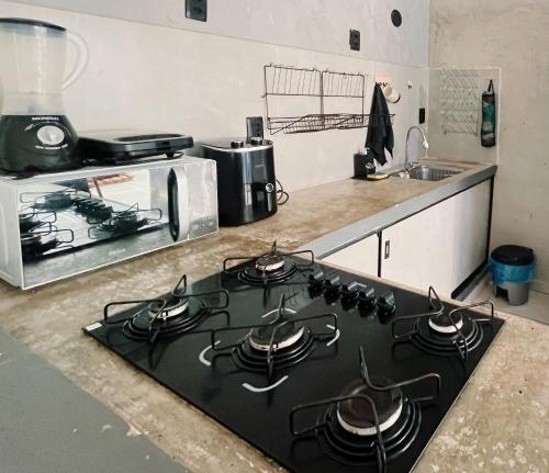 a stove top in a kitchen with a microwave at Surf & Arte Hostel in Cabo Frio