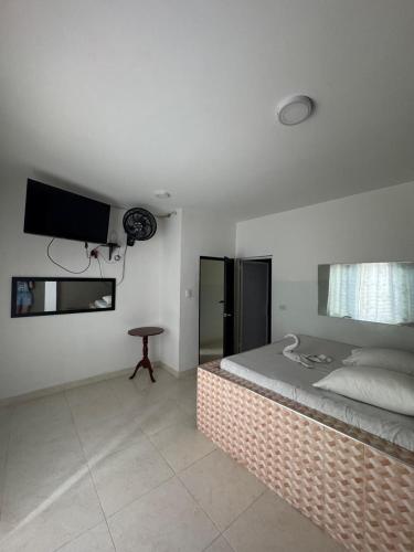 a bedroom with a bed and a television on the wall at HOSPEDAJE CASANOVA FlORIDA VALLE in Florida