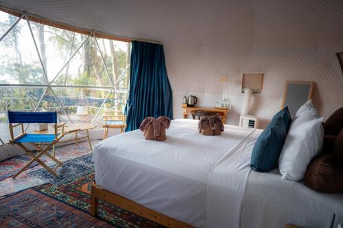 a bedroom with a large white bed and a large window at NATUR - Krabi Campsite Glamping & Camping in Krabi