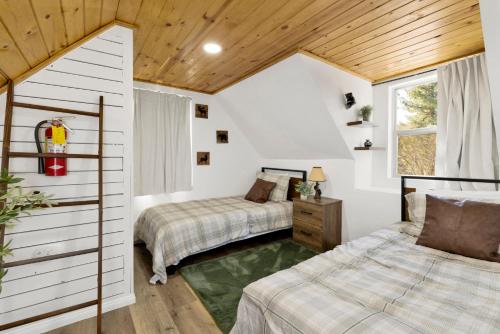 a bedroom with two beds and a window at Shiloh Woods Cabin Walk to Lake & Village Fireplace Cozy Retreat in Big Bear Lake