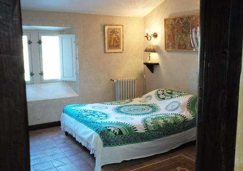 un dormitorio con una cama y una ventana en Logis de la Robliniere, en Landevieille
