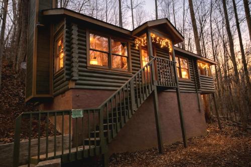 a tiny house with a staircase in the woods at Timber Wood, Log Cabin, Private Hot Tub, WiFi, Fireplace in Sevierville