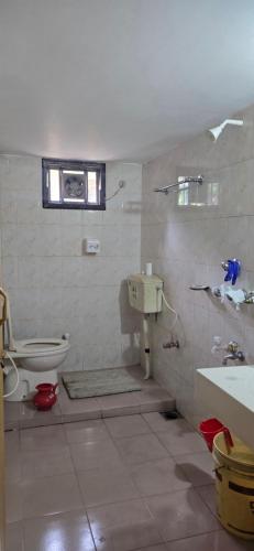 a bathroom with a toilet and a sink at Shanti villa in Kadipur