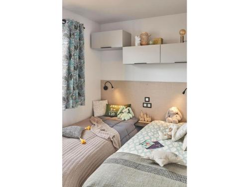 a bedroom with two beds and a couch at Mobile home Keiheuvel 6p in Balen