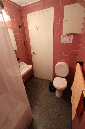 a bathroom with a toilet and a sink and a door at Sierras & Urbana in Tandil