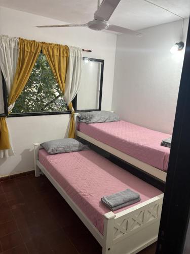 two beds in a room with a window at Jerarquizado M Rentals in Santiago del Estero