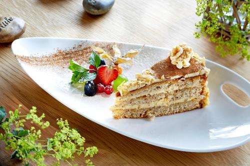 a piece of cake on a white plate on a table at Hotel Tirol Fiss 4Sterne Superior in Fiss