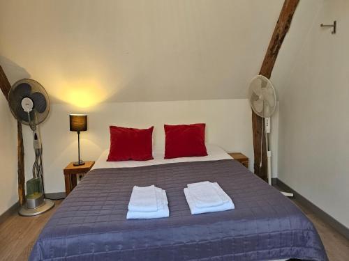 a bedroom with a large bed with two red pillows at Spacious Durbuy Apartment for 6 in Durbuy