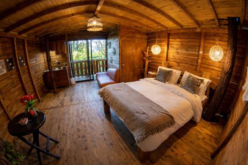 a bedroom with a bed in a log cabin at Refugio Natural - Guarne - Cabañas Ecológicas con Jacuzzi e hidromasaje in Guarne