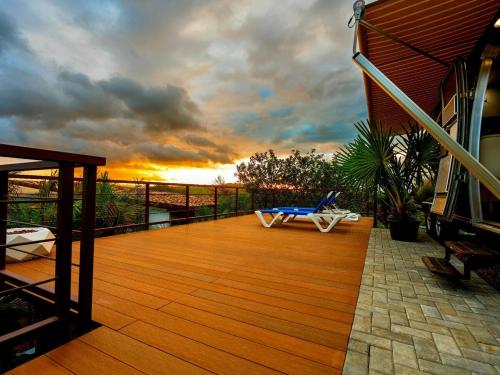 a wooden deck with a chair on a house at Airstream Stay Private Jacuzzi & Volcano View in Monterrey