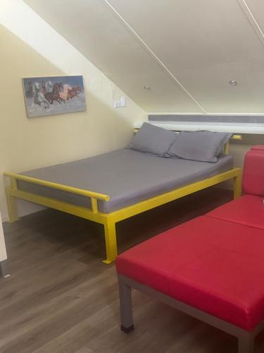 a bed in a room with a red couch at D'Schnuggs Place in Panglao Island