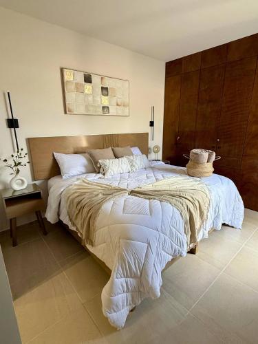 a bedroom with a large bed with a wooden headboard at Encanto Department We Bill in Alcocer