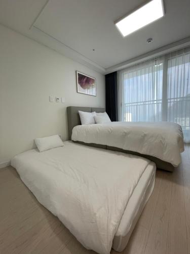 a bedroom with two beds and a window at 서프리조트 양양 빅웨이브 in Yangyang