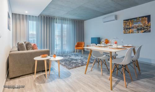 a living room with a couch and a table and chairs at Innapartments - São Gonçalinho in Aveiro