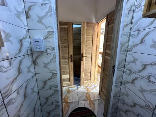 a door leading into a room with marble walls at Jajoux Homes in Azohoué-Hiho