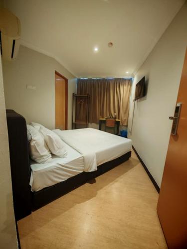 a bedroom with a large bed with white sheets and pillows at Swing & Pillows - Dataran Nilai in Nilai