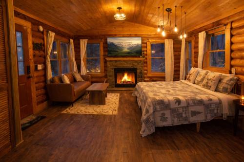 a bedroom with a bed and a fireplace in a log cabin at Timber Wood, Log Cabin, Private Hot Tub, WiFi, Fireplace in Sevierville