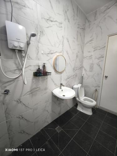 a bathroom with a toilet and a sink and a mirror at Kulim Modern Bungalow in Kulim