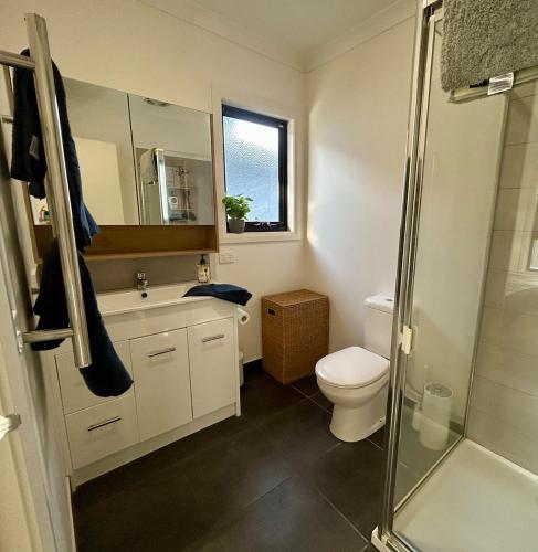 a bathroom with a toilet and a sink and a shower at Modern Gem Steps from Everything You Need in Croydon North