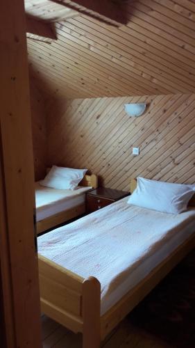 two beds in a room with a wooden ceiling at Holiday Home Aleksic in Žabljak