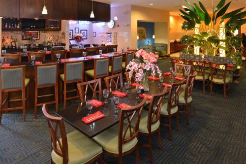 a restaurant with tables and chairs and a bar at Holiday Inn Montgomery Airport South by IHG in Hope Hull