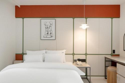 a bedroom with a large white bed and a desk at 그루브 호텔 Groove Hotel in Jeonju