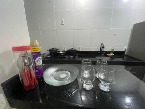 a kitchen counter with glasses and a plate on it at Ap Turquesa in Teresina