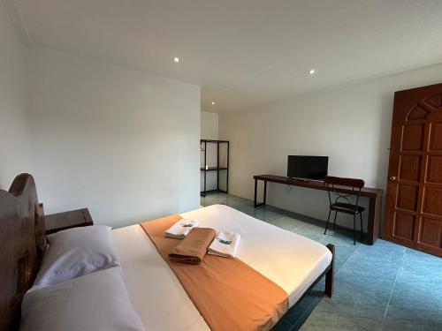 a bedroom with a bed and a desk with a computer at Balay Inato Pension in Puerto Princesa City