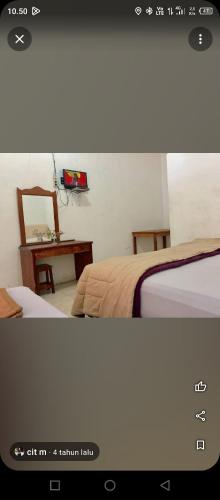 a bedroom with two beds and a table with a mirror at Kings guest house in Tuktuk Siadong