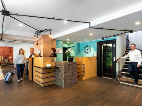 a group of people walking around a store at ibis Styles Macon Centre in Mâcon