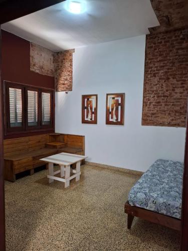 a room with a bed and a table in it at De Paso Pergamino in Pergamino