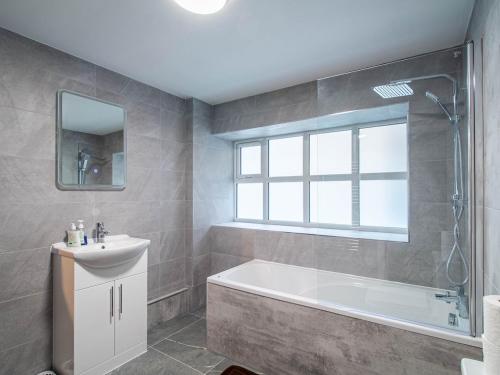a bathroom with a tub and a sink and a window at Central Doncaster Court House Stay in Doncaster