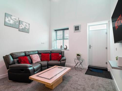 a living room with a leather couch and a coffee table at Central Doncaster Court House Stay in Doncaster