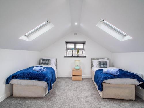two beds in a room with white walls at Central Doncaster Court House Stay in Doncaster