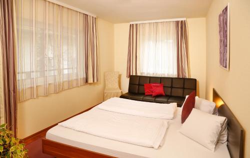 a small bedroom with a bed and a couch at Pension Sendlhofer in Radstadt